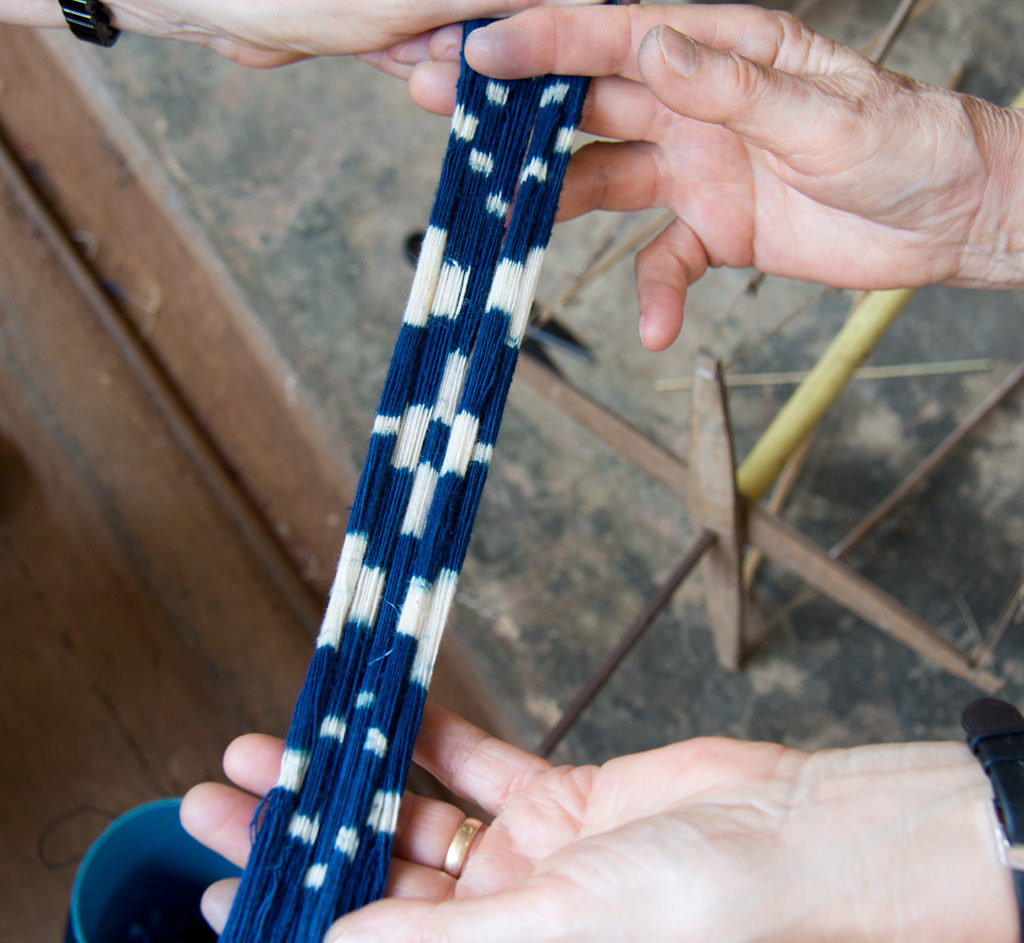 Réserves enlevées après teinture des fils à l'indigo en prévision d'un tissage façon ikat